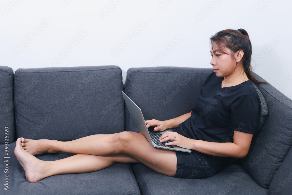 Woman working on laptop at home. Asian female remote working on notebook at home office. Modern tech. New Normal. Work from home concept Woman working on laptop at home. Asian female remote working on notebook at home office. Modern tech. New Normal. Work from home concept