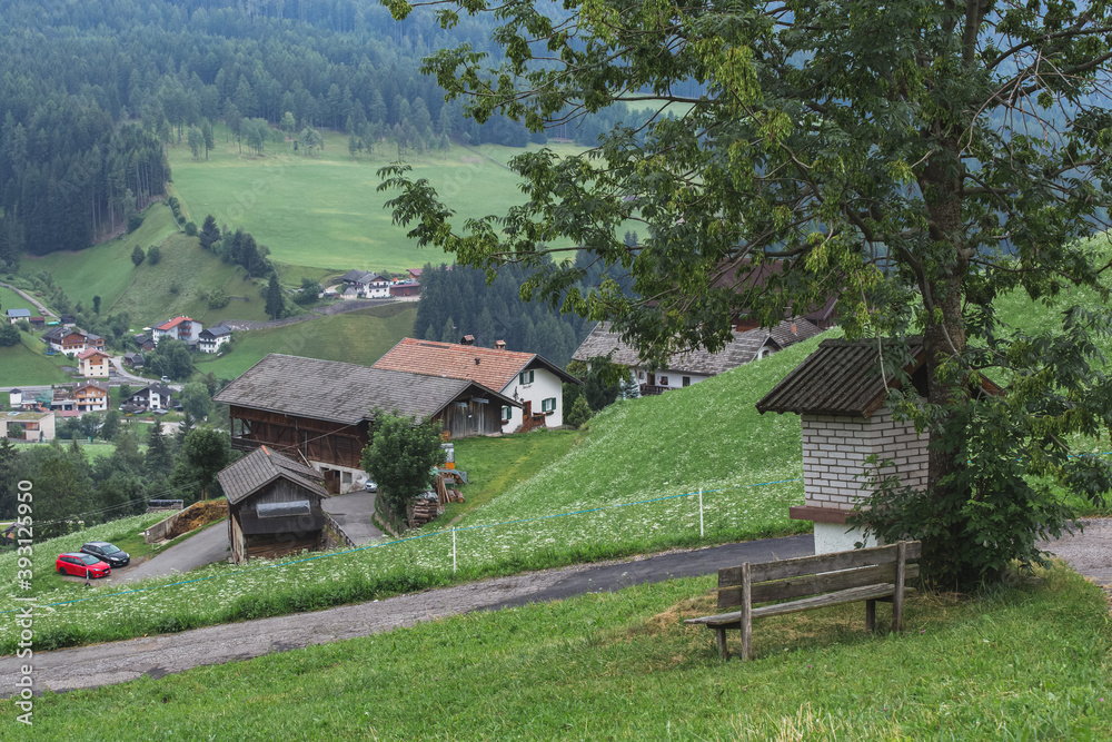 Natural landscape of small village in Dolomites, Italy, hillside grassland and retro small houses Natural landscape of small village in Dolomites, Italy, hillside grassland and retro small houses