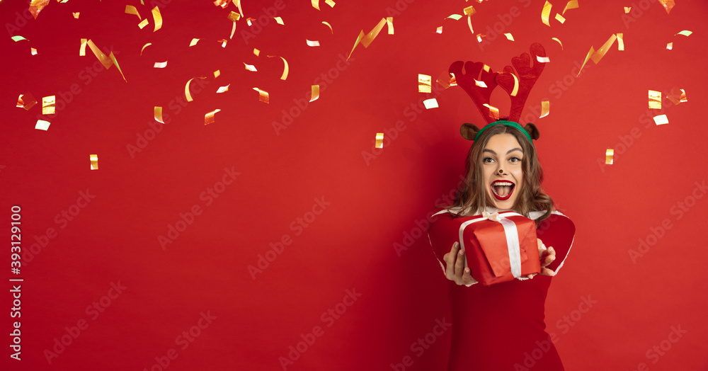 Greeting flyer for ad. Concept of Christmas, 2021 New Year's party, winter mood, holidays. Copyspace, postcard. Beautiful caucasian woman in like Santa's Deer giving gifts and laughting, confetti. Greeting flyer for ad. Concept of Christmas, 2021 New Year's party, winter mood, holidays. Copyspace, postcard. Beautiful caucasian woman in like Santa's Deer giving gifts and laughting, confetti.