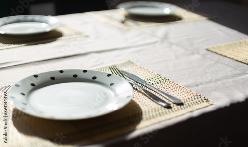 Simple table service with small mat tablecloths, plates, forks and knives