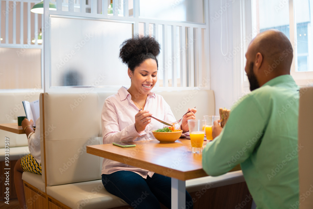 Brazilian female boss eating at office cafeteria. . Brazilian female boss eating at office cafeteria. .