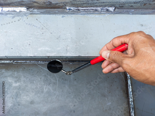 Using welding inspection mirror for check visual welding defects in a niche.