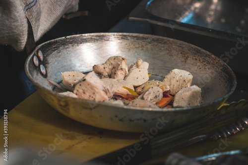 Chicken and vegetables frying in a pan.