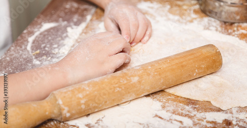 dough in flour kneading childrens hands. cooking concept. on the kitchen.household help. food preparation.