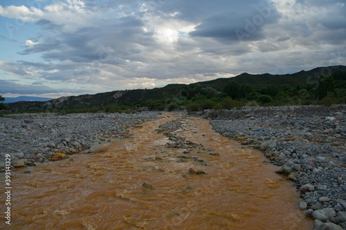 Environmental. View of the yellow river flowing across the rocky valley, mountains and forest at sunset.  photo