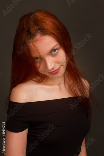 portrait of a beautiful red haired young positive woman in studio