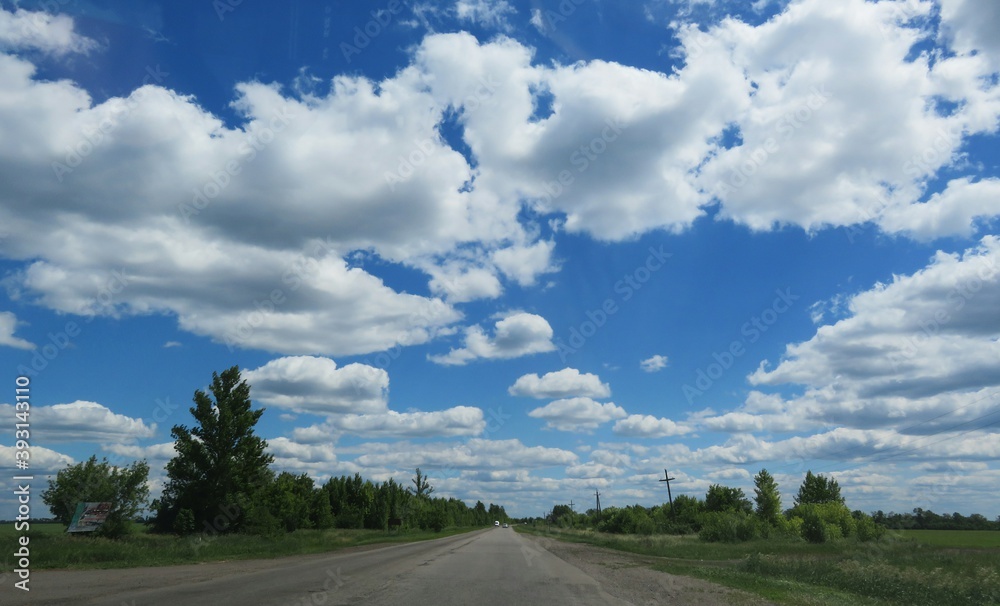 Fototapeta premium Road landscape with beautiful cloudscape in blue sky, europe