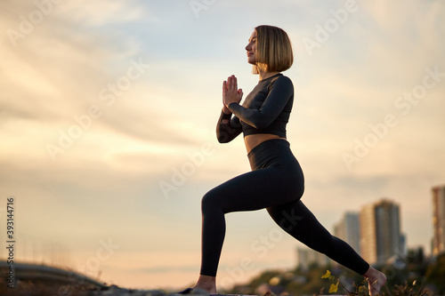 attractive strong woman is stretching exercising outdoors, summer time. healthy lifestyle, fitness and sport concept