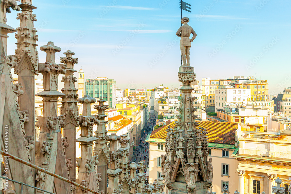 Obraz premium Roof of Milan Cathedral Duomo di Milano with Gothic spires and white marble statues. Top tourist attraction on piazza in Milan, Lombardia, Italy. Wide angle view of old Gothic architecture and art.