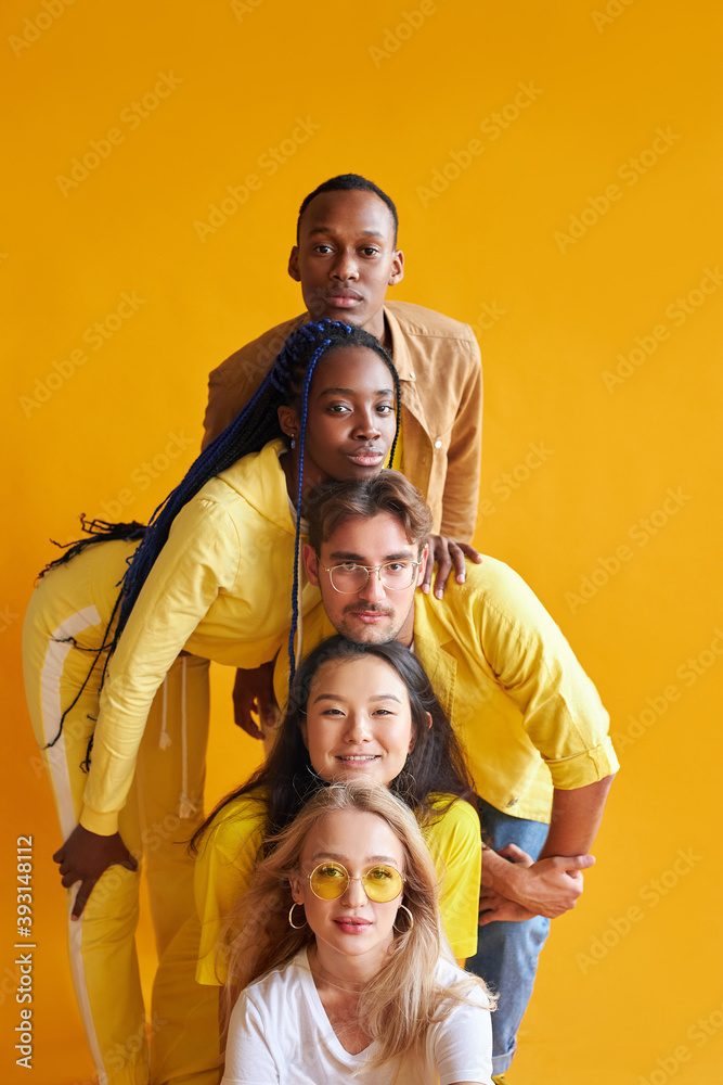 group of multiethnic friends, people of different cultures isolated on yellow background, good-looking men and women in stylish wear posing, students in one country