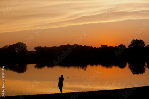 silhouette of a person fishing