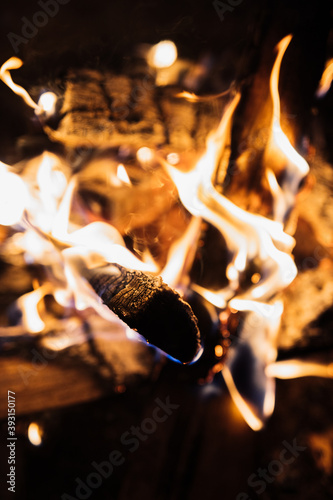From above camping fireplace with burning firewood in snowy winter day