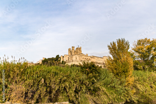 Vue depuis les rives de l'Orb sur la cathédrale Saint-Nazaire de Béziers au coucher du soleil (Occitanie, France)