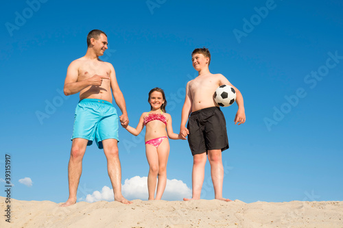 Family sports games on the beach on a sunny day. Family on vacation, vacation, sports and active lifestyle concept. Golden hour.