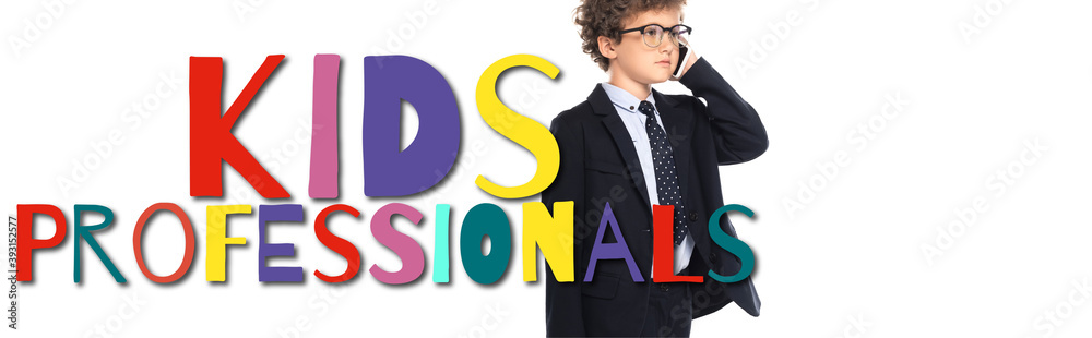 curly boy in suit and glasses talking on smartphone near kids professionals lettering on white, banner curly boy in suit and glasses talking on smartphone near kids professionals lettering on white, banner
