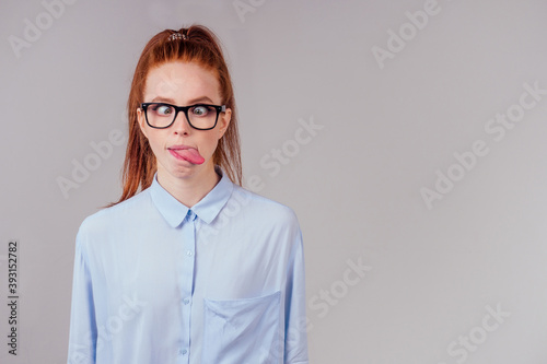 redhair ginger woman demonstrating tongue and making stupid face with crossed eyes photo