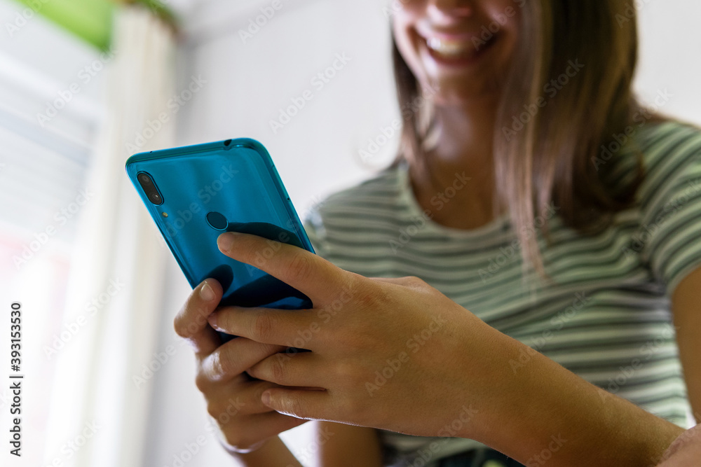 From below of unrecognizable female reading messages on social media via cellphone and chilling at home at weekend From below of unrecognizable female reading messages on social media via cellphone and chilling at home at weekend
