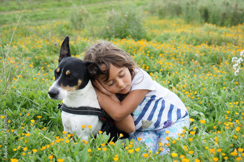 Beautiful Terrier in a meadow with her friend, a 5 year old girl
