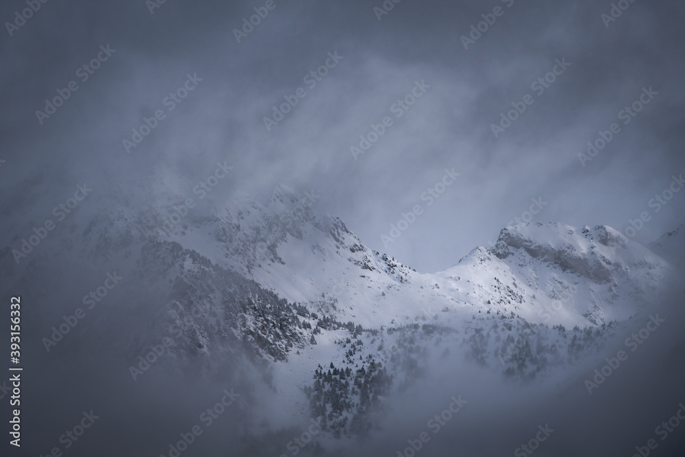 Spectacular scenery of Pyrenees mountain range covered with snow against cloudy sky in winter Spectacular scenery of Pyrenees mountain range covered with snow against cloudy sky in winter