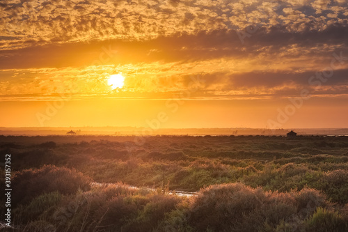 sunset with cloudy sky over the marshes of Huelva, Spain.