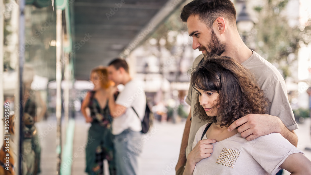 Group of people in shopping mall looking new fashion clothes at shop window of a boutique. Shop sales. Black friday concept Group of people in shopping mall looking new fashion clothes at shop window of a boutique. Shop sales. Black friday concept