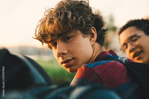 Portrait of male teenager with friends standing in city photo