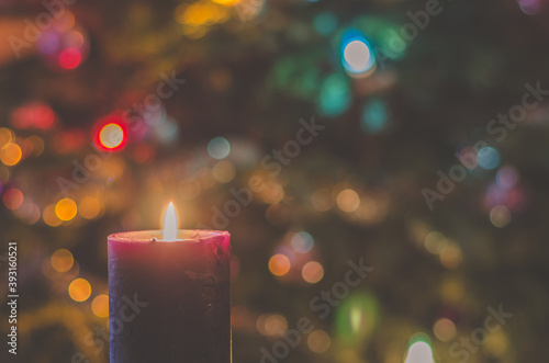 christmas festive concept with christmas tree lights and burning candle