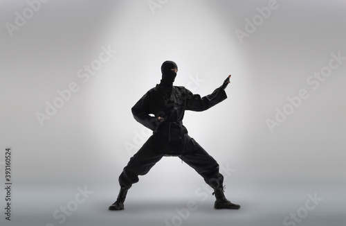 japanese ninja in black uniform, on grey background