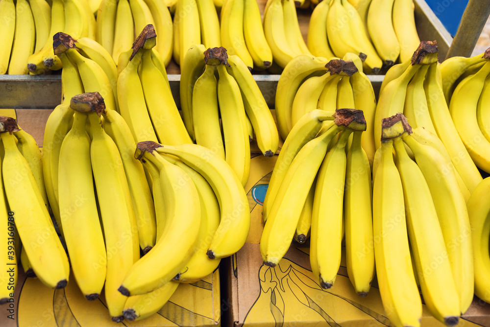 Bundles of ripe bananas on a counter at farmers market