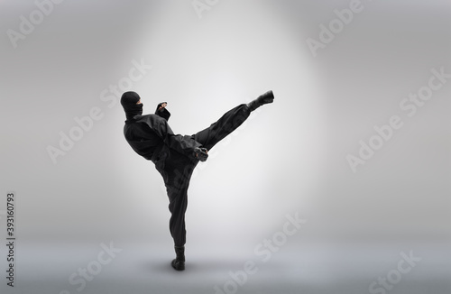 Photo japanese ninja in black uniform, on grey background