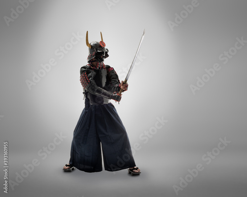 japanese samurai in black uniform with katana sword, on grey background photo