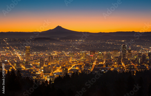 Scenic view of city with silhouetted Mount Hood in background during sunrise photo