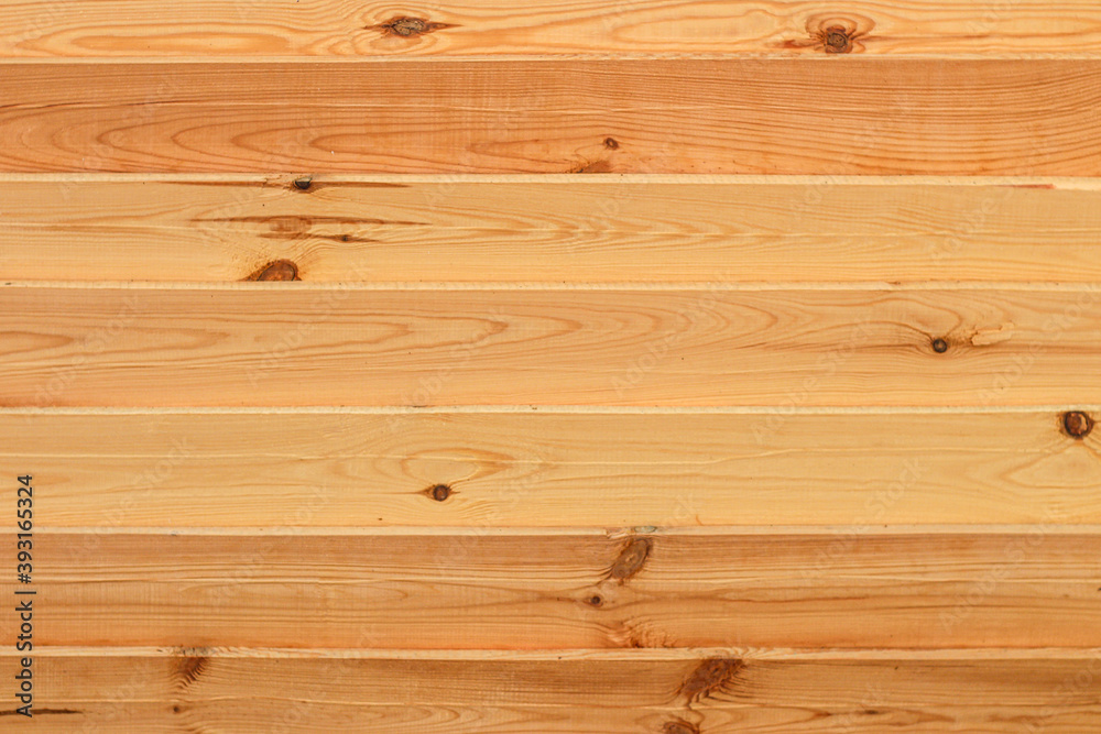 Fototapeta premium Texture of fresh wooden boards. Horizontal planks shield. Rough sawn pine boards stack on the construction site