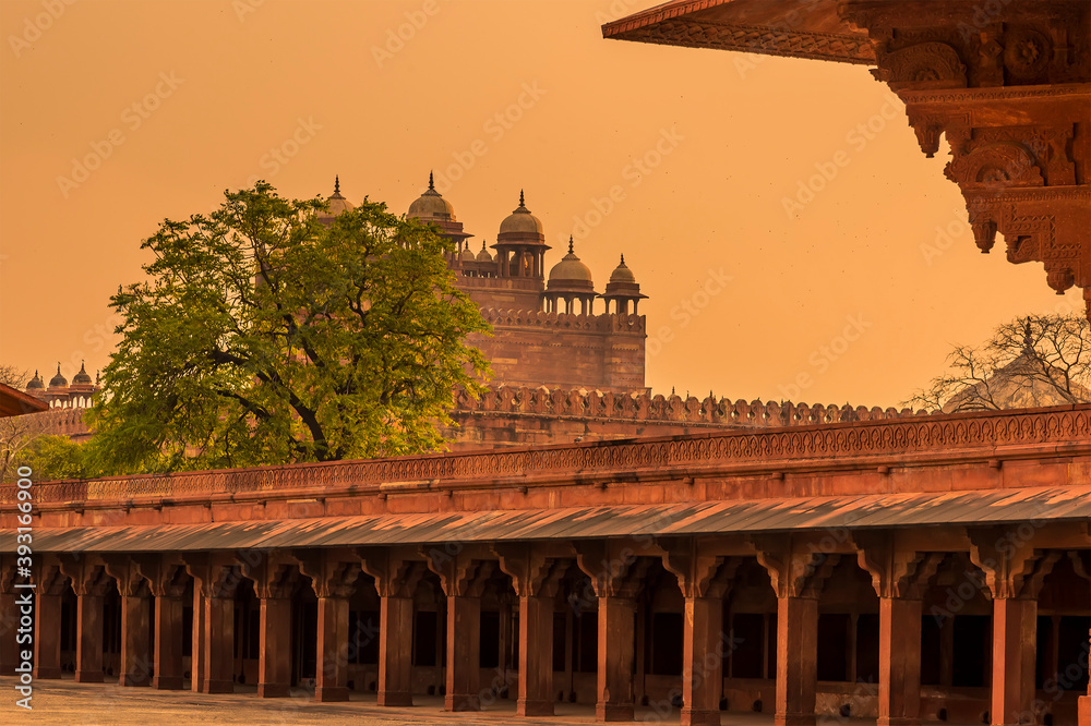 Fototapeta premium The western side of the abandoned temple complex walls at Fathepur Sikri, India glows after sunset