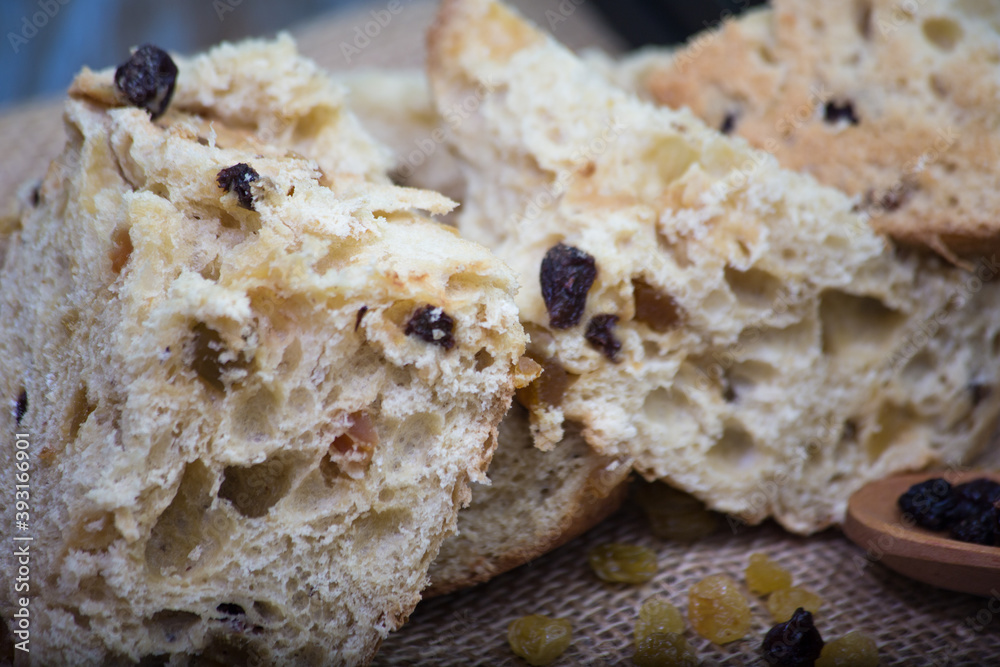 panettone soft bread with raisin. rustic background with christmas ornament