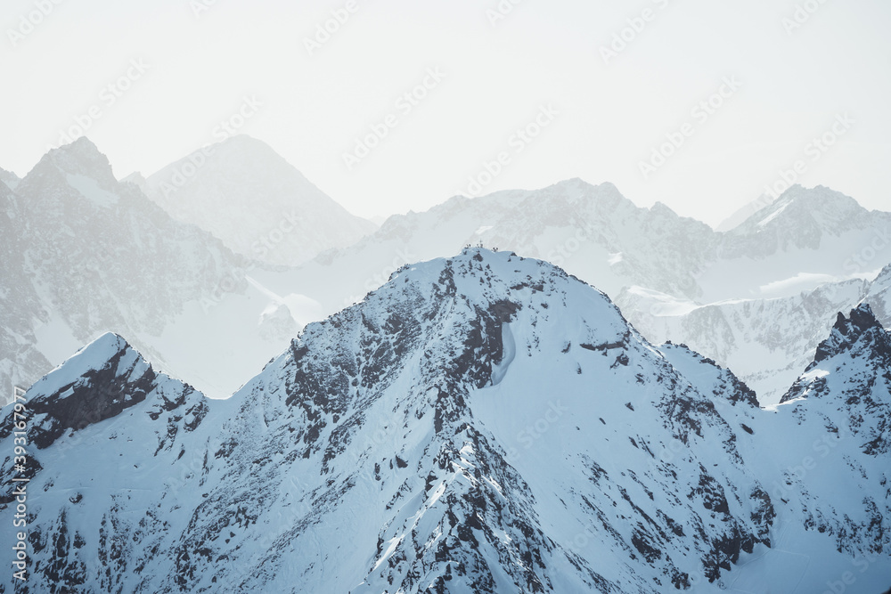 Fototapeta premium Snow mountain landscape with a sommet with mountaineers around a cross