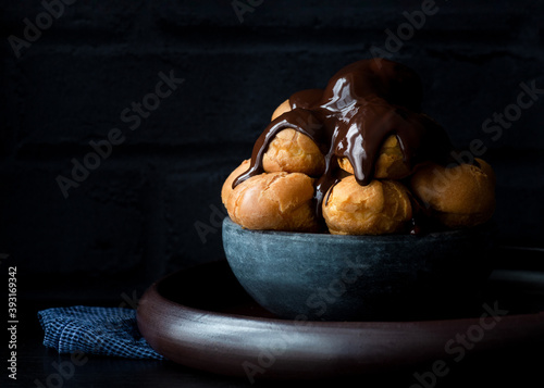 Принти на полотні Profiteroles , choux pastry covered  in a dark rich chocolate sauce