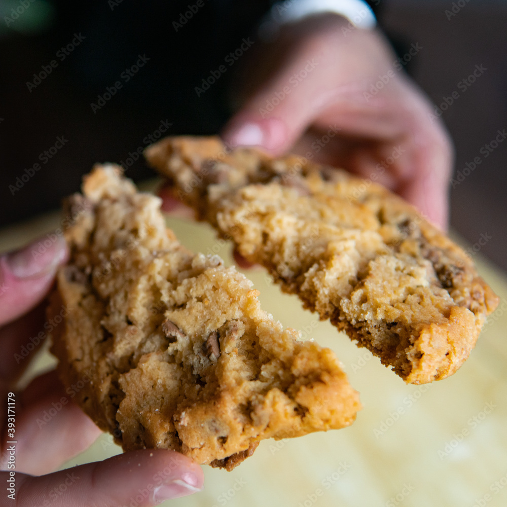 chocolate cookie split in two by a woman chocolate cookie split in two by a woman