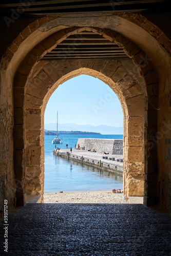 Fotografie view through a medieval arch towards the sea in front of cefalu
