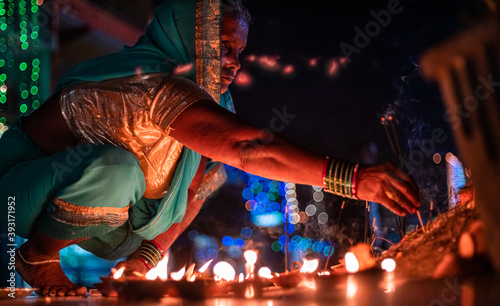 Wallpaper Mural Closeup Middle-aged woman offers prayers with incense stick on the night of Diwali outdoors. Torontodigital.ca
