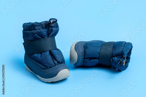 Winter blue warm boots for newborns on light blue background flat lay copy space. Children's small shoes. Fashionable fabric autumn winter boots with rubber soles. Children's fashion. Boots for boy