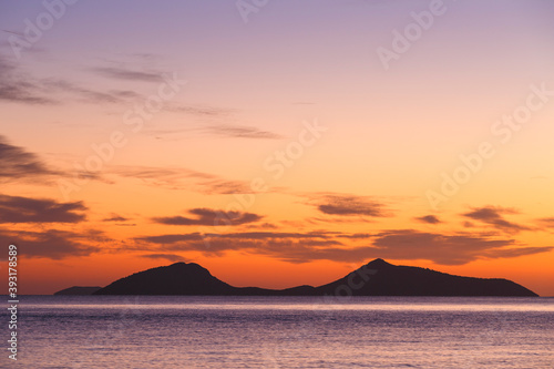 View of Trikeri island against colorful morning sky from Spetses. photo