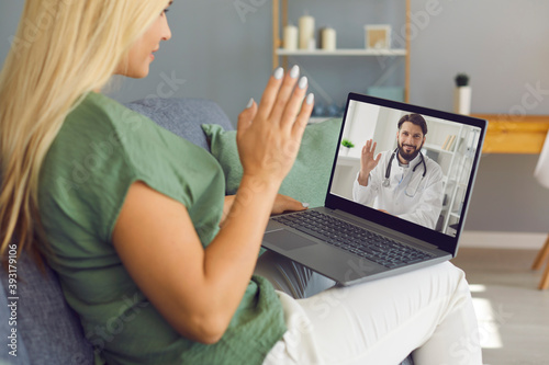 Side view of a woman making a video call with her doctor while staying at home feeling unwell.