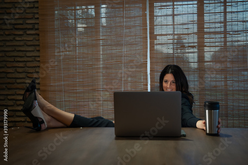 woman in high heels at a table teleworking