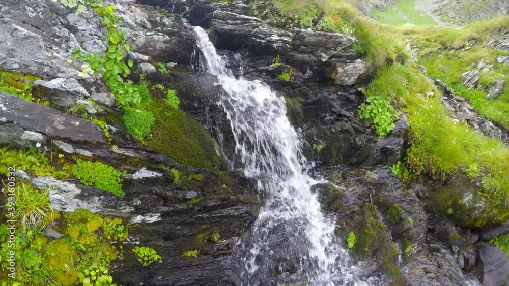 Summer waterfall in mountain, water stream on mountain rocks Summer waterfall in mountain, water stream on mountain rocks