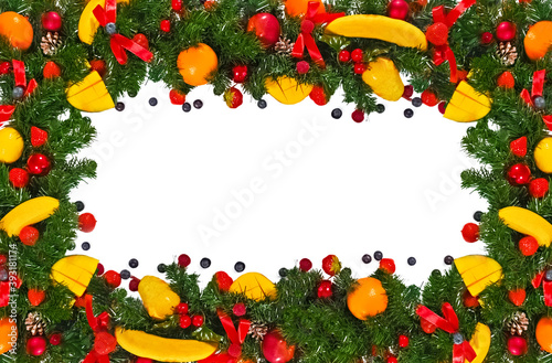 Christmas creative fun frame made of fir branches decorated with fruits, berries and bows, isolated on a white background.flat lay, top view.Mockup, copy space.The concept of a new year