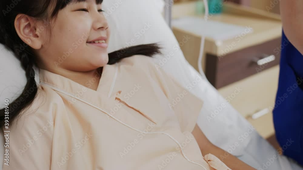 Close up :Asian smiling nurse smile and take care little asia girl patient on bed at hospital room ER. Doctor woman in blue uniform give blanket cover for sick kid. Children's Hospital Pediatric Ward. Close up :Asian smiling nurse smile and take care little asia girl patient on bed at hospital room ER. Doctor woman in blue uniform give blanket cover for sick kid. Children's Hospital Pediatric Ward.