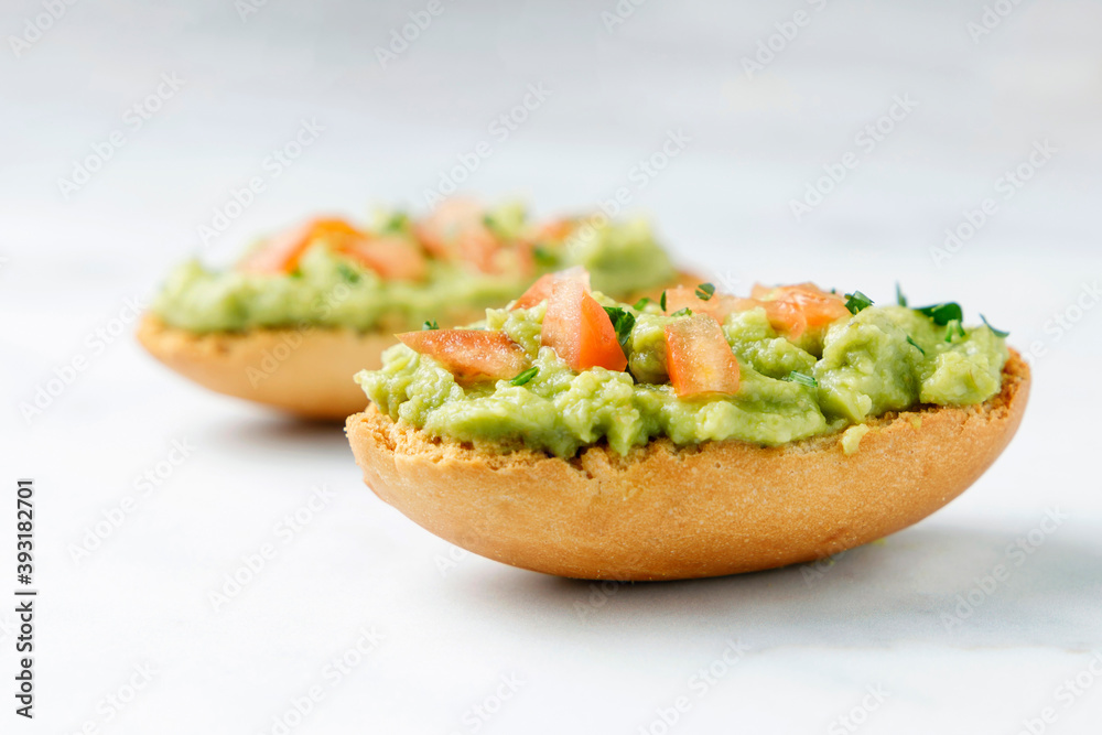 Guacamole toasts with tomato and parsley