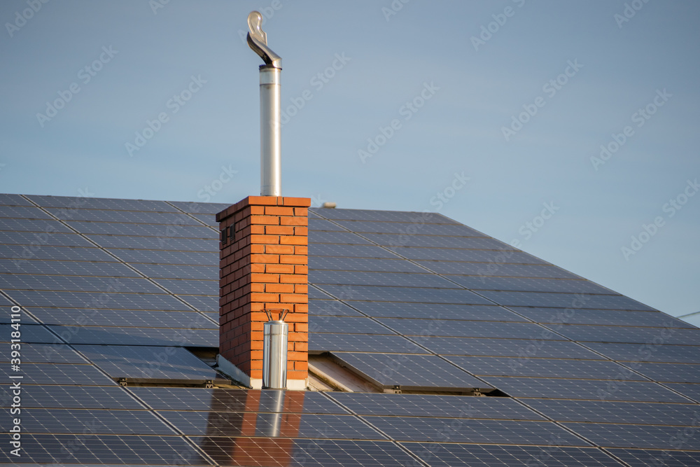 Solar panels on the roof and brick flue chimney, photovoltaic panels ...