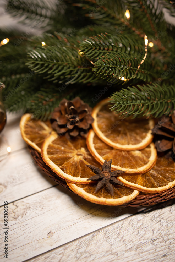 dried orange in a basket with garland and fir branches and cones. Christmas morning holiday concept. Flat lay.